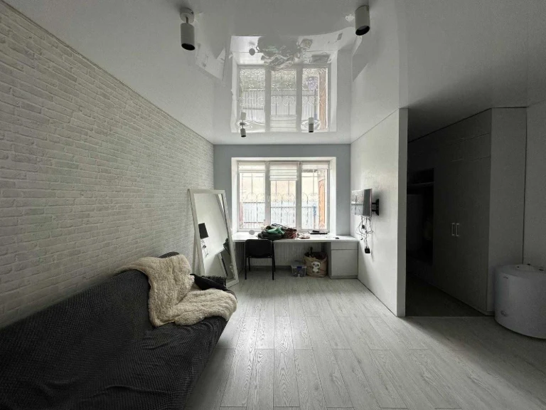 Spacious furnished studio apartment with appliances.