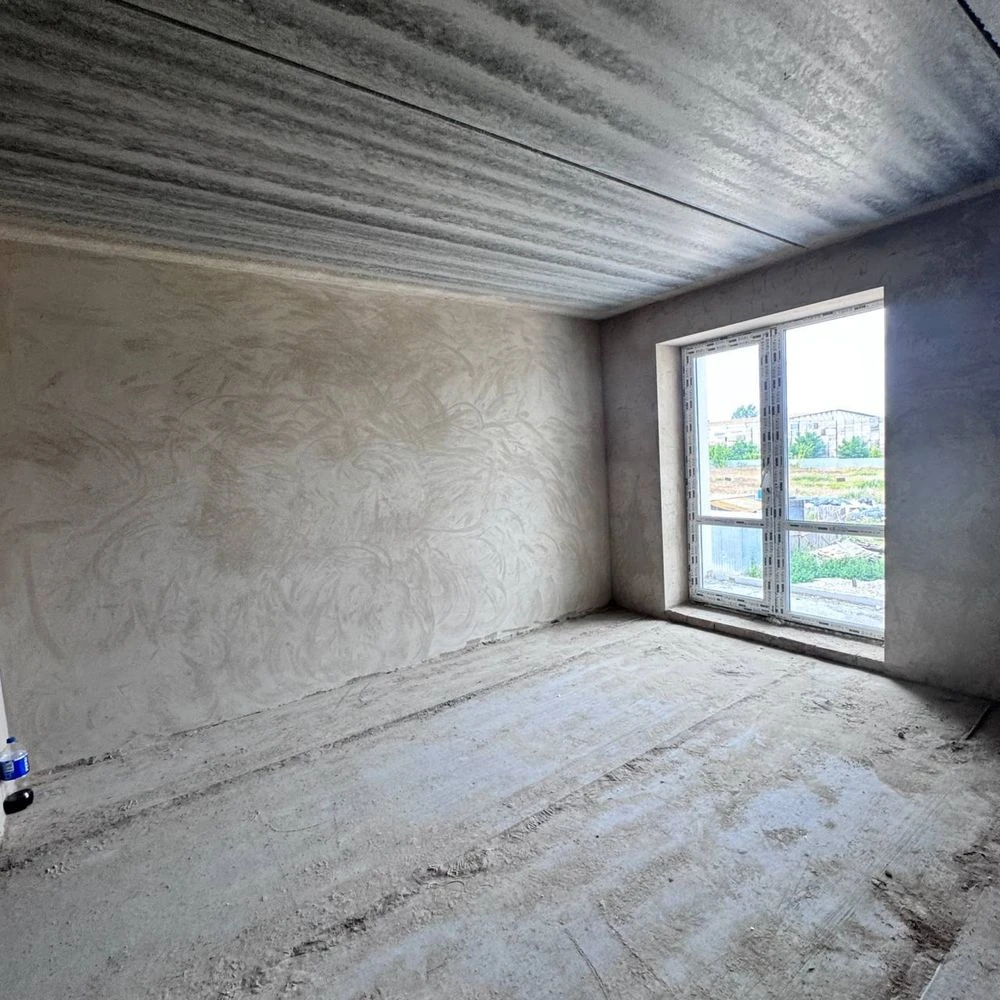 Spacious apartment with unfinished interior in a completed building,