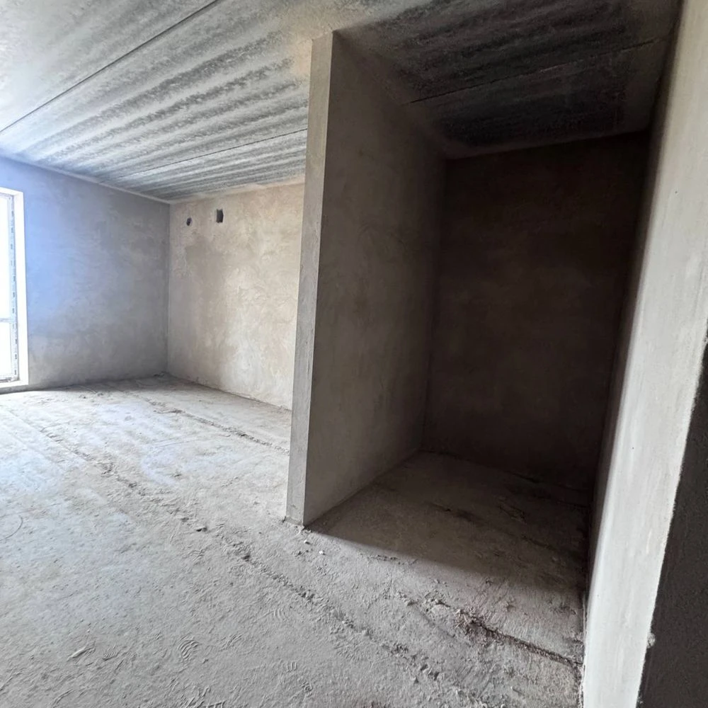 Spacious apartment with unfinished interior in a completed building,