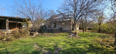 Large plot with an unfinished building and residential structure, suburb.