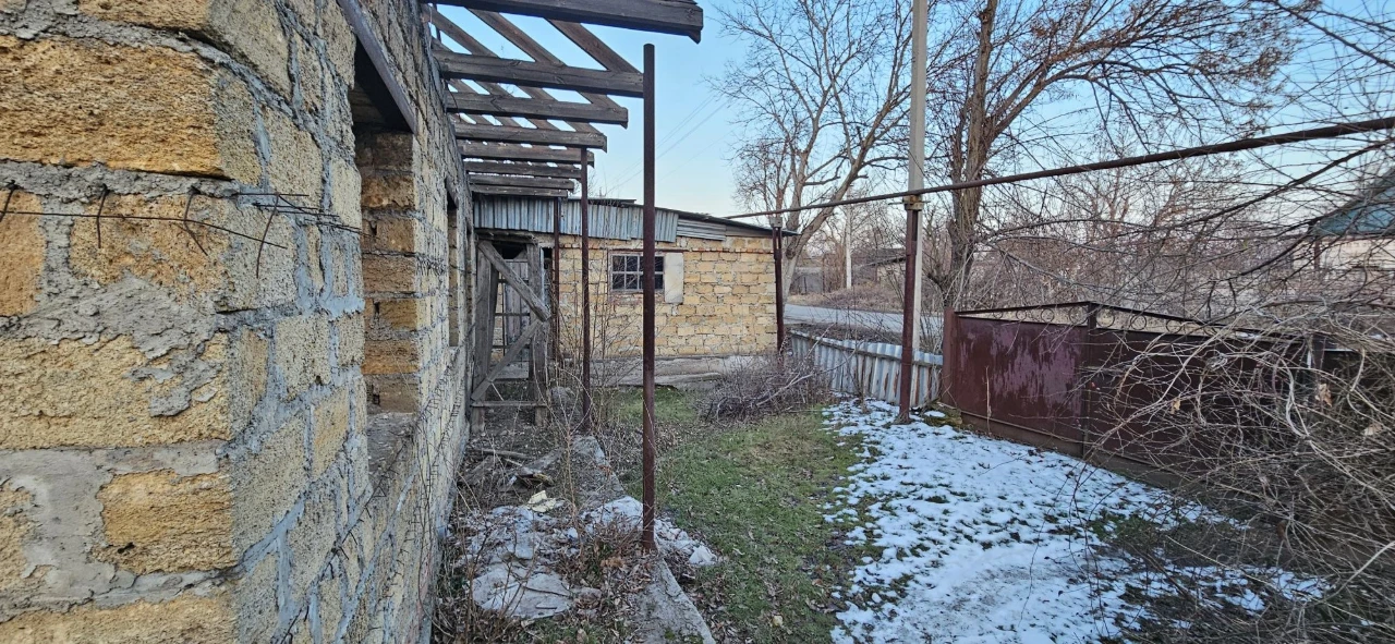 Large plot with an unfinished building and residential structure, suburb.
