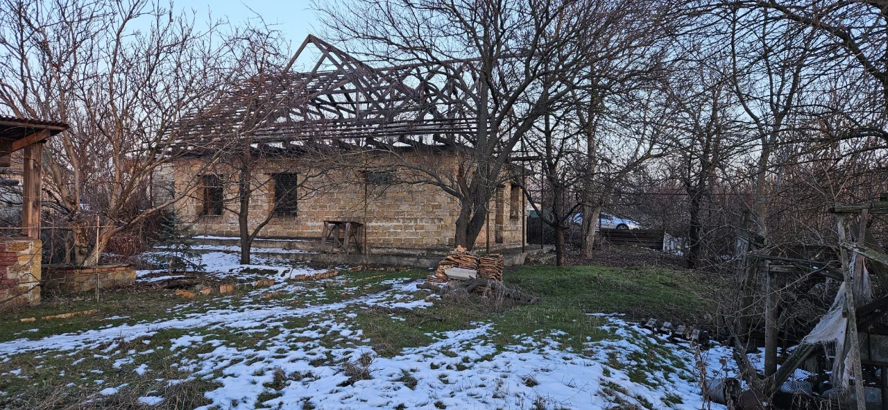 Large plot with an unfinished building and residential structure, suburb.