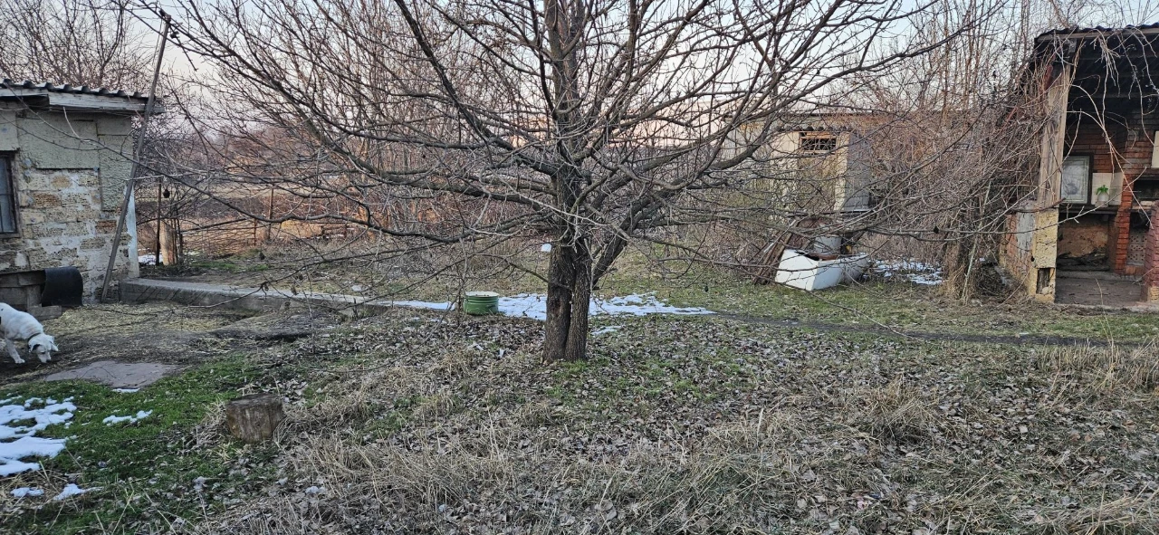 Large plot with an unfinished building and residential structure, suburb.