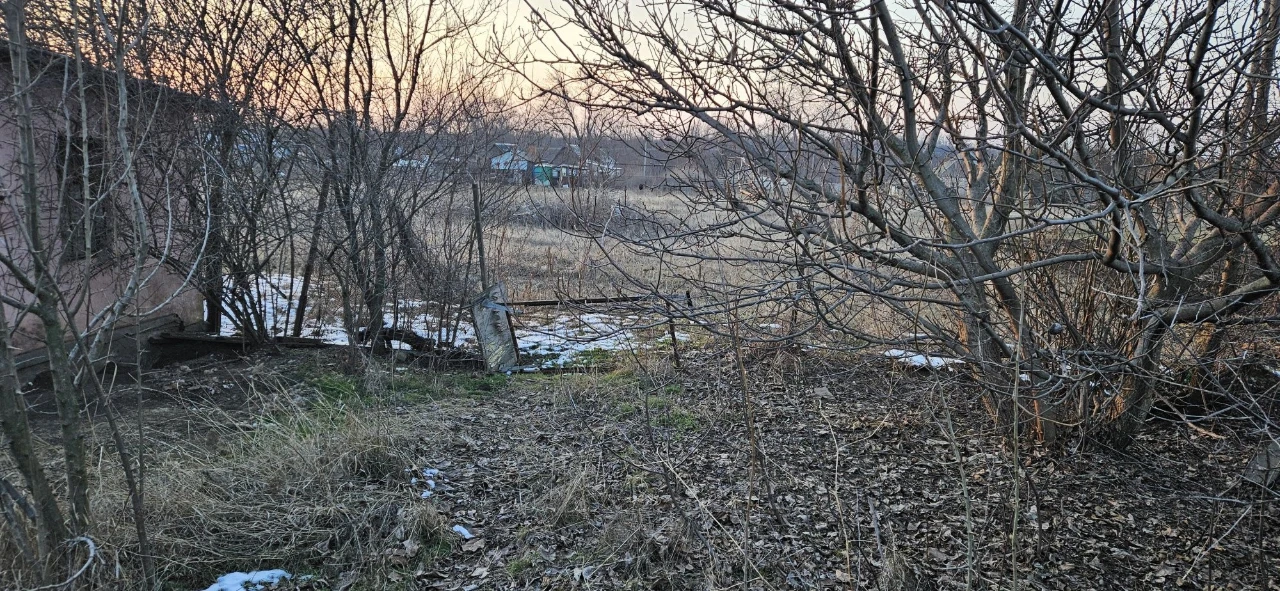 Large plot with an unfinished building and residential structure, suburb.