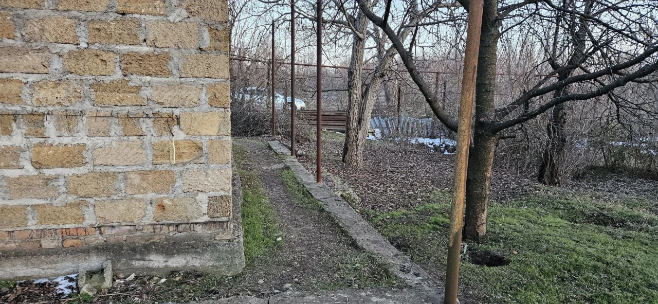 Large plot with an unfinished building and residential structure, suburb.