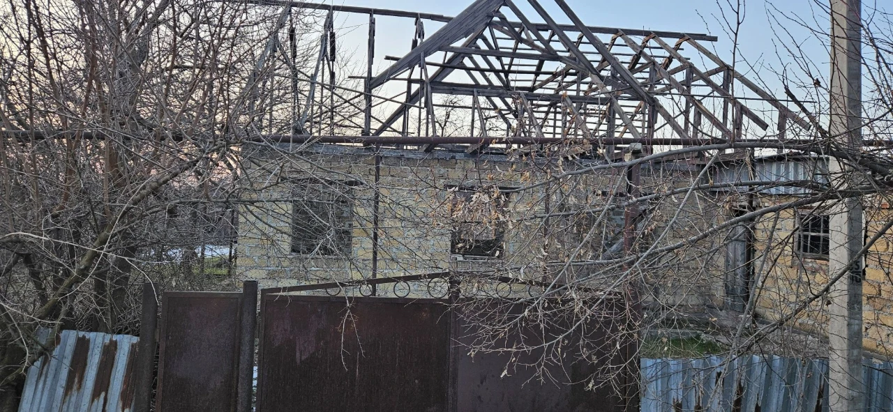 Large plot with an unfinished building and residential structure, suburb.
