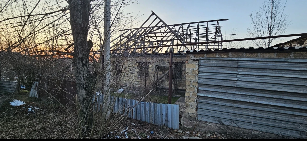 Large plot with an unfinished building and residential structure, suburb.