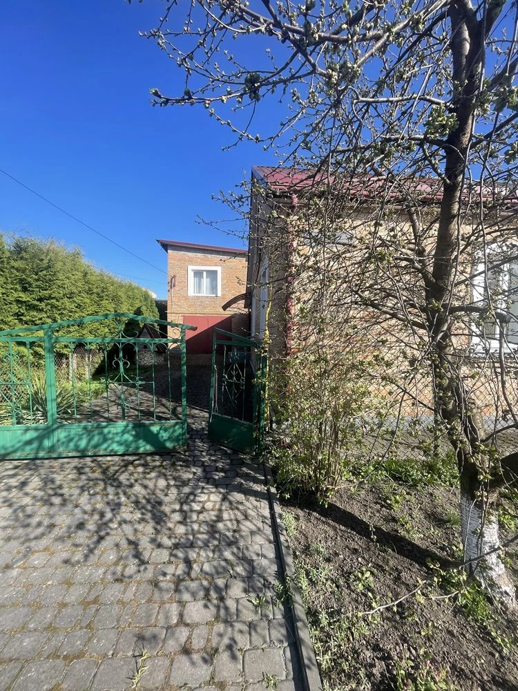 Частина будинку з житловою добудовою та гаражем
